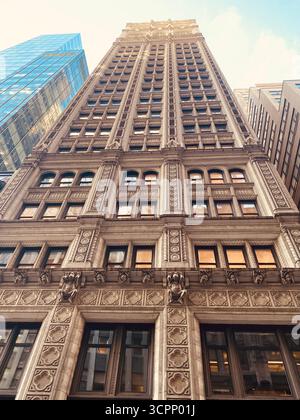 Grattacielo neogotico con facciata decorata vista da Low Angle sotto il cielo blu Foto Stock