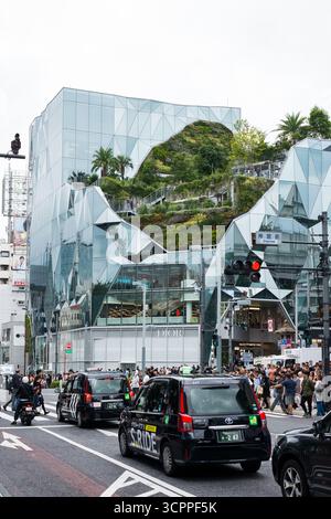 TOKYO, GIAPPONE - 27 OTTOBRE 2024 - immagine verticale di taxi neri vicino al Tokyu Plaza Harajuku 'HARAKADO', un edificio dall'architettura moderna a Tokyo Foto Stock