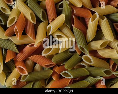 Tricolore penne Macro Food Pattern - primo piano, sfondo full-frame di penne tricolore (macaroni) crude, secche, in verde, giallo e rosso. Ideale Foto Stock
