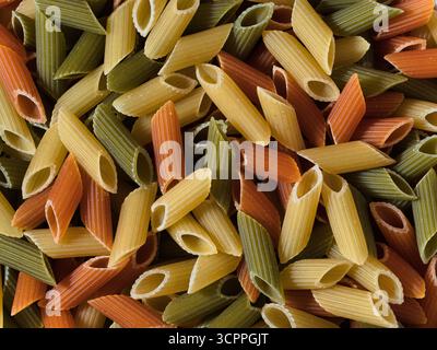 Tricolore penne Macro Food Pattern - primo piano, sfondo full-frame di penne tricolore (macaroni) crude, secche, in verde, giallo e rosso. Ideale Foto Stock