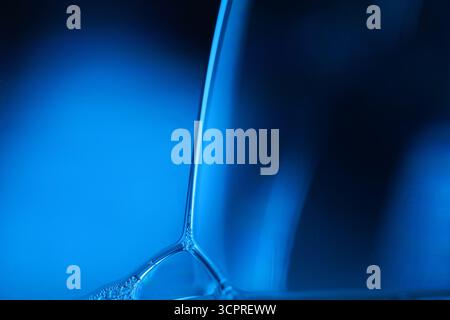 Superficie liquido blu, movimento macchie di olio, chimica brillante, sfondo surreale, arcobaleno blu artico, superficie dell'acqua, inchiostro e acqua Foto Stock