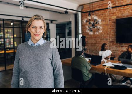 Ritratto di una donna professionista professionista professionista che indossa un maglione in ufficio Foto Stock