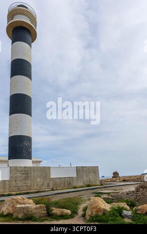 Il faro di San Javier, situato sul mare a la Manga del Mar Menor, si innalza verso il cielo con le sue impressionanti strisce bianche e nere. Foto Stock