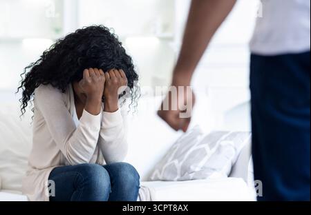 La violenza domestica. Spaventata donna nasconde il suo volto in mani. Foto Stock