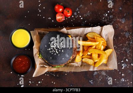 Vista dall'alto dell'hamburger Black Bun con spicchi di patate Foto Stock