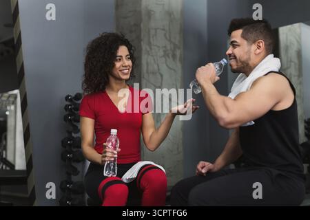 Una coppia di fitness si riposa e parla in palestra Foto Stock