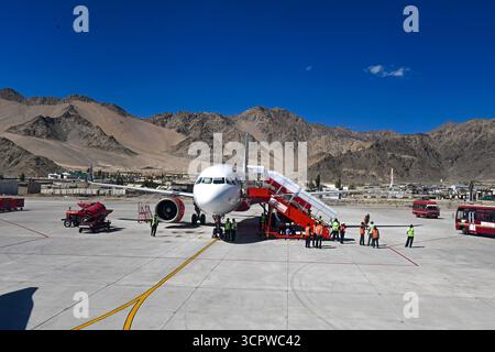 Leh, Ladakh, India. 28 settembre 2025. Un aereo di stanza sull'asfalto all'aeroporto di Leh, circondato da equipaggio di terra e veicoli di supporto, con lo splendido sfondo delle aride e aspre montagne del Ladakh sotto un cielo blu profondo. L'aeroporto di Leh, ufficialmente noto come aeroporto Kushok Bakula Rimpochee, è uno dei più alti aeroporti commerciali del mondo, situato nel territorio dell'unione di Ladakh, India. (Credit Image: © Basit Zargar/ZUMA Press Wire) SOLO PER USO EDITORIALE! Non per USO commerciale! Foto Stock