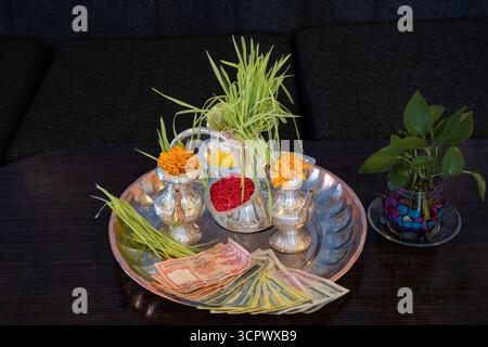 Tika e Jamara sono stati messi in un utensile d'argento con germogli d'orzo, soldi e frutta per la cerimonia Vijaya Dashami durante il festival Dashain in Nepal. Foto Stock