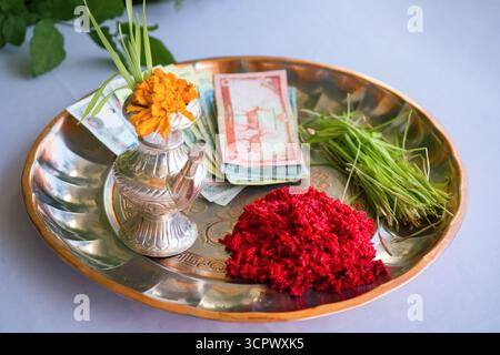 Tika e Jamara sono stati messi in un utensile d'argento con germogli d'orzo, soldi e frutta per la cerimonia Vijaya Dashami durante il festival Dashain in Nepal. Foto Stock