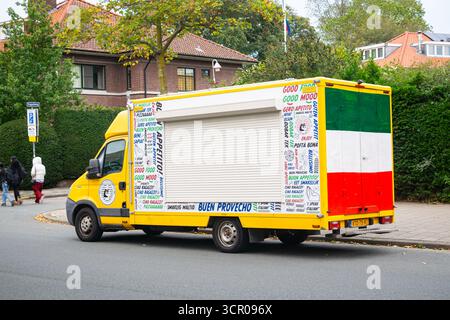 Colorato food truck italiano parcheggiato in una strada tranquilla che serve piatti autentici durante gli spostamenti Foto Stock