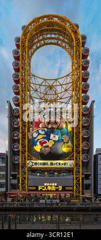 osaka, dotonbori - 6 dicembre 2024: Ruota panoramica giapponese a forma ovale di Don Quijote store, mascotte di pinguino Donpen con Ebisu dio dei pescatori Foto Stock