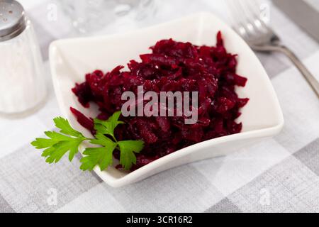 Popolare insalata russa, a base di barbabietola grattugiata bollita, decorata con erbe aromatiche Foto Stock