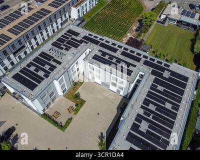Vista aerea che mostra più pannelli solari installati su tetti piani di edifici contemporanei. Foto Stock