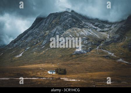 Solitary White Cottage ai piedi di una montagna nelle Highlands scozzesi - Scozia Foto Stock