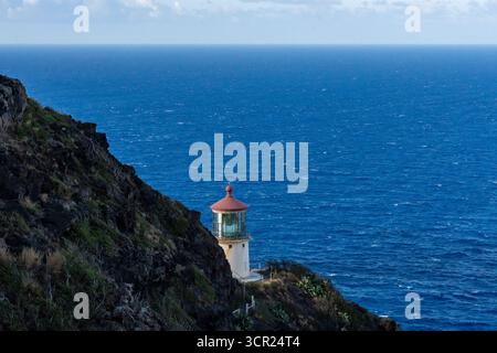 Una vista mozzafiato del faro di Makapu'u sulla costa orientale di Oahu, dove la ricca storia marittima delle Hawaii incontra le incontaminate scogliere oceaniche e l'oceano blu profondo Foto Stock