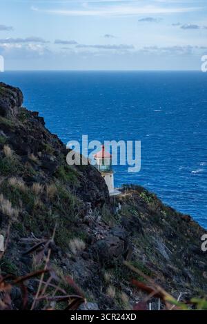 Una vista mozzafiato del faro di Makapu'u sulla costa orientale di Oahu, dove la ricca storia marittima delle Hawaii incontra le incontaminate scogliere oceaniche e l'oceano blu profondo Foto Stock