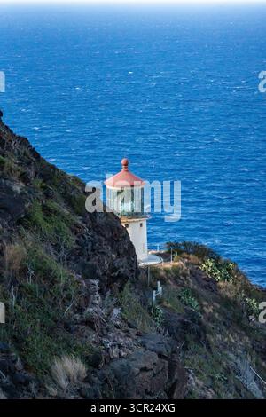 Una vista mozzafiato del faro di Makapu'u sulla costa orientale di Oahu, dove la ricca storia marittima delle Hawaii incontra le incontaminate scogliere oceaniche e l'oceano blu profondo Foto Stock