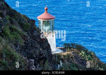 Una vista mozzafiato del faro di Makapu'u sulla costa orientale di Oahu, dove la ricca storia marittima delle Hawaii incontra le incontaminate scogliere oceaniche e l'oceano blu profondo Foto Stock