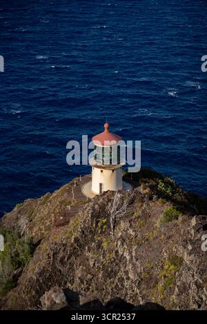 Una vista mozzafiato del faro di Makapu'u sulla costa orientale di Oahu, dove la ricca storia marittima delle Hawaii incontra le incontaminate scogliere oceaniche e l'oceano blu profondo Foto Stock