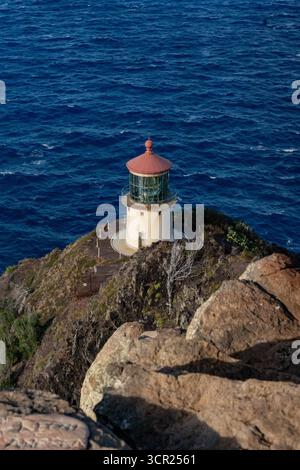 Una vista mozzafiato del faro di Makapu'u sulla costa orientale di Oahu, dove la ricca storia marittima delle Hawaii incontra le incontaminate scogliere oceaniche e l'oceano blu profondo Foto Stock