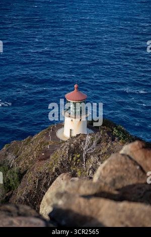 Una vista mozzafiato del faro di Makapu'u sulla costa orientale di Oahu, dove la ricca storia marittima delle Hawaii incontra le incontaminate scogliere oceaniche e l'oceano blu profondo Foto Stock