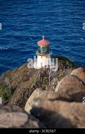 Una vista mozzafiato del faro di Makapu'u sulla costa orientale di Oahu, dove la ricca storia marittima delle Hawaii incontra le incontaminate scogliere oceaniche e l'oceano blu profondo Foto Stock