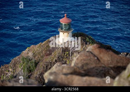 Una vista mozzafiato del faro di Makapu'u sulla costa orientale di Oahu, dove la ricca storia marittima delle Hawaii incontra le incontaminate scogliere oceaniche e l'oceano blu profondo Foto Stock