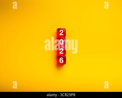 Dadi rossi impilati per formare il numero 2026 su sfondo giallo. Concetto creativo per il nuovo anno, nuovo inizio, pianificazione, opportunità e visione futura. Ideale Foto Stock