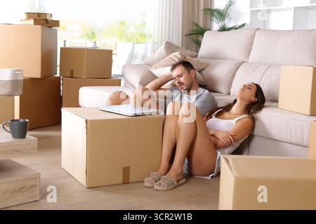 Coppia triste e stanca che riposa e si lamenta mentre si trasferisce a casa Foto Stock