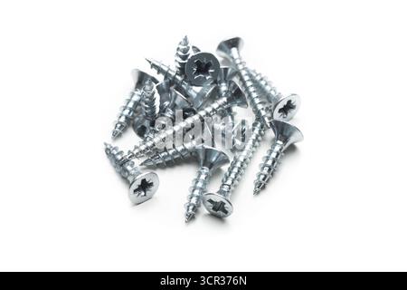 Collezione di viti argentate disposte su sfondo bianco per le attività di costruzione Foto Stock