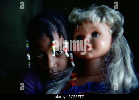 Una ragazza gioca con una bambola nella sezione Liberty City di Miami, Florida. Foto Stock