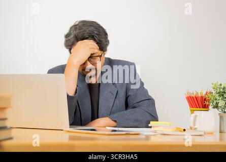 Mal di testa, stanchezza e stress. Il ritratto di un uomo in tuta ha mal di testa emicrania. Concetto di mal di testa. Gli uomini dolorosi sono stressati al lavoro in ufficio. Stre Foto Stock