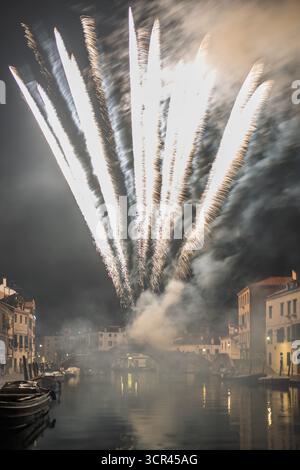 I luminosi fuochi d'artificio illuminano il cielo notturno sul Canal de Cannaregio, riflettendo sull'acqua e creando un'atmosfera festosa nella Venezia storica. Foto Stock