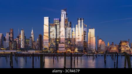 Vista panoramica al crepuscolo dei grattacieli di Hudson Yards e dello skyline di Midtown Manhattan che si riflette sul fiume Hudson. Paesaggio urbano serale di New York City, Stati Uniti Foto Stock