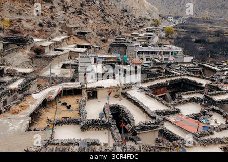 Vista aerea di un villaggio in pietra annidato in un aspro paesaggio montano. Marpha, Annapurna, distretto di Mustang della provincia di Gandaki, Nepal Foto Stock