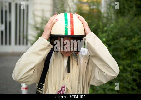Casco da donna regolabile con strisce bandiera italiana all'aperto in una giacca leggera. Berlino, Germania Foto Stock
