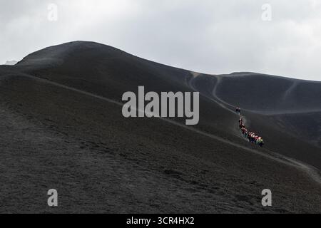 Monte Etna, Catania, Sicilia, Italia - 21 settembre 2025: Escursionisti trekking sul terreno vulcanico dell'Etna - avventura ed esplorazione nel Foto Stock