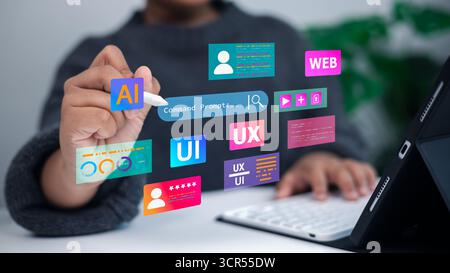 Designer che utilizza un tablet con icone UX, ai e sviluppo Web dell'interfaccia utente virtuale. Concetto di progettazione digitale, esperienza utente, creazione di interfacce e Modern te Foto Stock