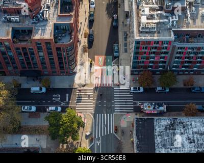 Veduta aerea della marciapiede bianca che taglia attraverso l'asfalto scuro, incorniciata dagli edifici in mattoni e dai toni rossi, Brooklyn, New York, Unite Foto Stock