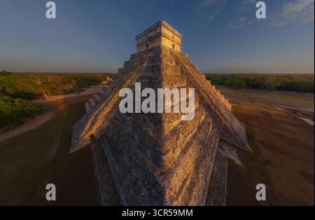 Vista aerea della maestosa piramide di Kukulkan, che sorge con antiche pietre all'orizzonte, bagnata dal caldo bagliore del sole che tramonta, Chichén Itzá, Yucatán, Messico. Foto Stock