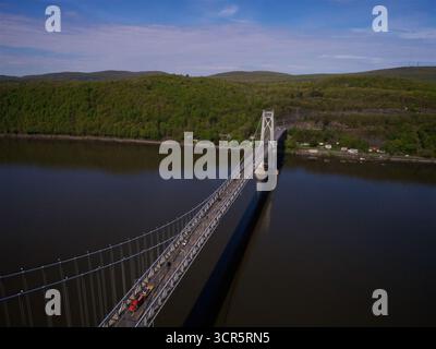Veduta aerea del Mid-Hudson Bridge che si estende attraverso il tranquillo fiume, collegando coste lontane sotto un cielo sereno, Poughkeepsie, New York, United Foto Stock