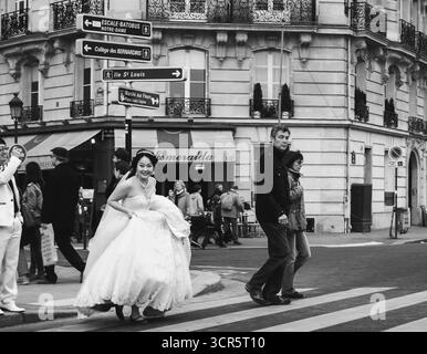 Parigi, Francia - 7 aprile 2012: Giovane sposa e sposo non identificati al crocevia nel centro della città. Foto storica in bianco e nero. Foto Stock