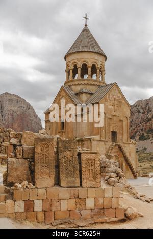 Vista dell'antico monastero di Noravank che si erge maestosamente su uno sfondo di aspre montagne e un cielo coperto, il monastero di Noravank, la provincia di Vayots Dzor, Armenia. Foto Stock