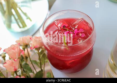 Tè alla bacca misto Earl Grey con decorazioni floreali in vetro, rinfrescante bevanda estiva per temi di salute e stile di vita da caffè. Foto Stock