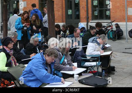 Dublino, Irlanda - 29 settembre 2025 - Un gruppo di artisti internazionali, al corso Ian Fennelly Urban Sketch, siediti insieme mentre disegna un edificio Temple Bar pub nella città di Dublino Foto Stock