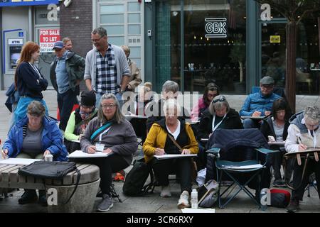 Dublino, Irlanda - 29 settembre 2025 - Un gruppo di artisti internazionali, al corso Ian Fennelly Urban Sketch, siediti insieme mentre disegna un edificio Temple Bar pub nella città di Dublino Foto Stock