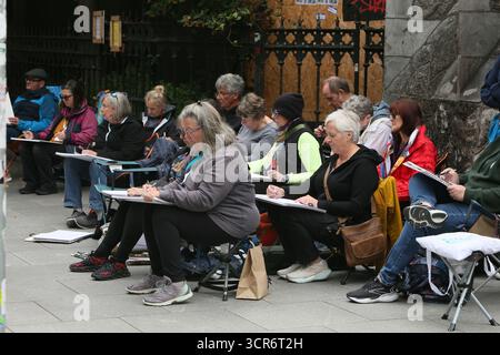 Dublino, Irlanda - 29 settembre 2025 - Un gruppo di artisti internazionali, al corso Ian Fennelly Urban Sketch, siediti insieme mentre abbozzi l'o'Neill's Pub in Suffolk Street nella città di Dublino Foto Stock