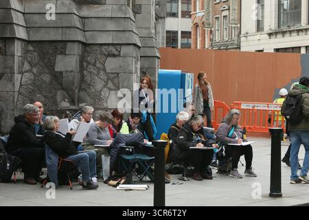 Dublino, Irlanda - 29 settembre 2025 - Un gruppo di artisti internazionali, al corso Ian Fennelly Urban Sketch, siediti insieme mentre abbozzi l'o'Neill's Pub in Suffolk Street nella città di Dublino Foto Stock