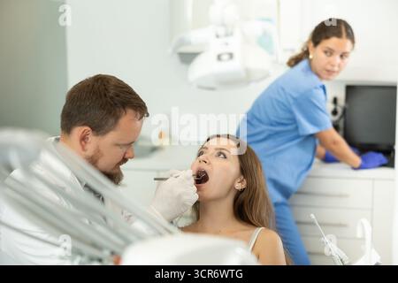 Donna che controlla i denti ad un appuntamento dal dentista Foto Stock