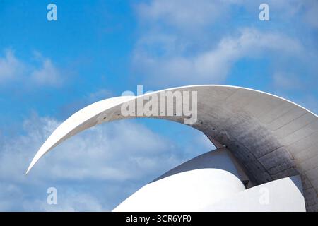 Struttura moderna in primo piano l'Auditorium "Adán Martín" di Tenerife ha un arco curvo in cemento contro un cielo blu con nuvole, l'architetto spagnolo Santiago Calatrava Foto Stock